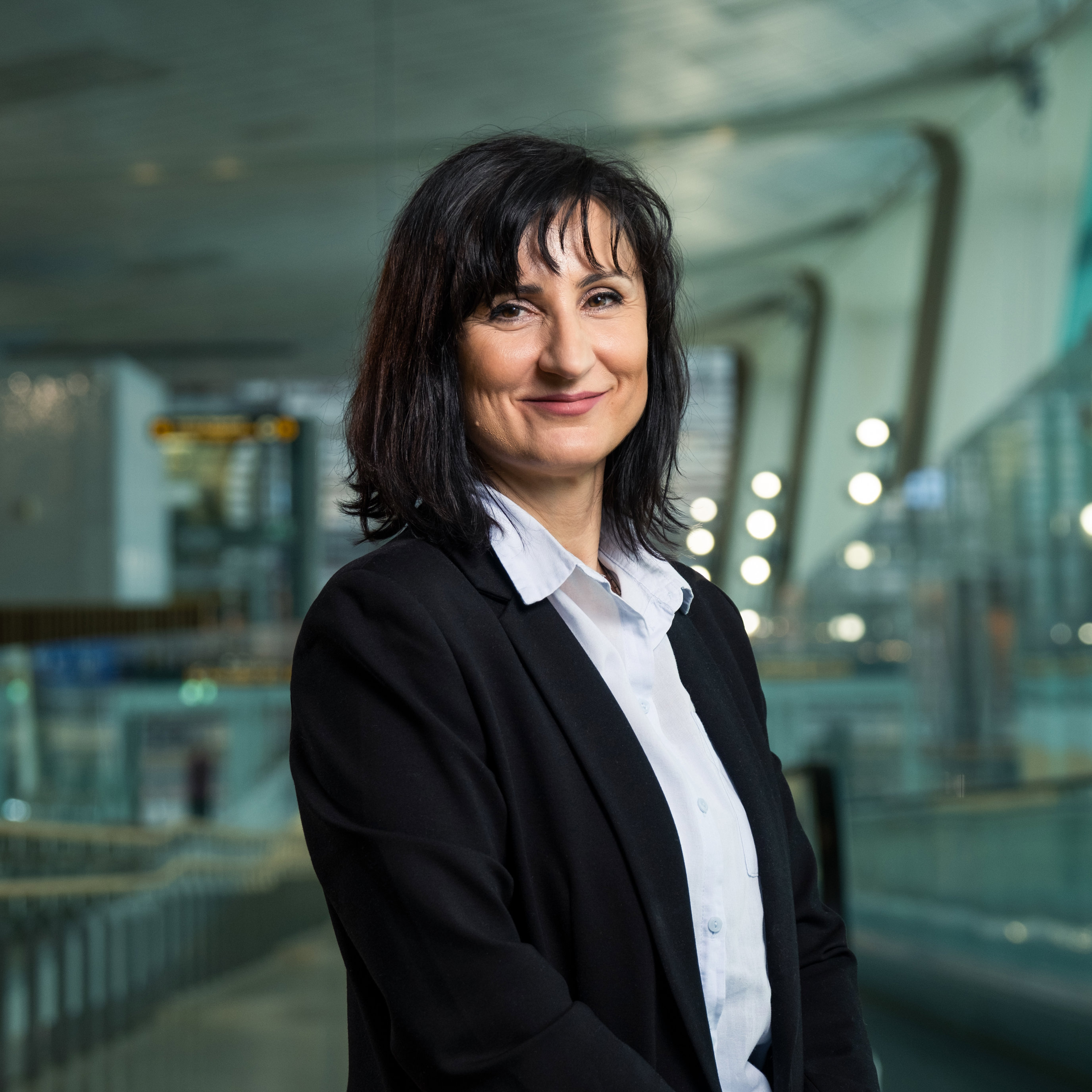 Profesjonell kvinne i forretningsklær som smiler i en moderne kontorbygning