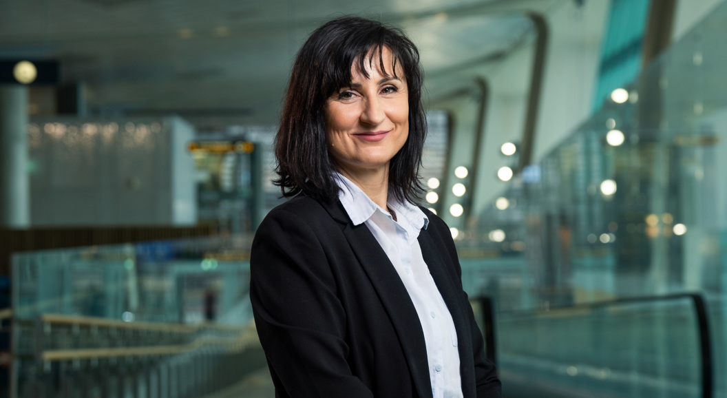 Profesjonell kvinne i forretningsklær som smiler i en moderne kontorbygning