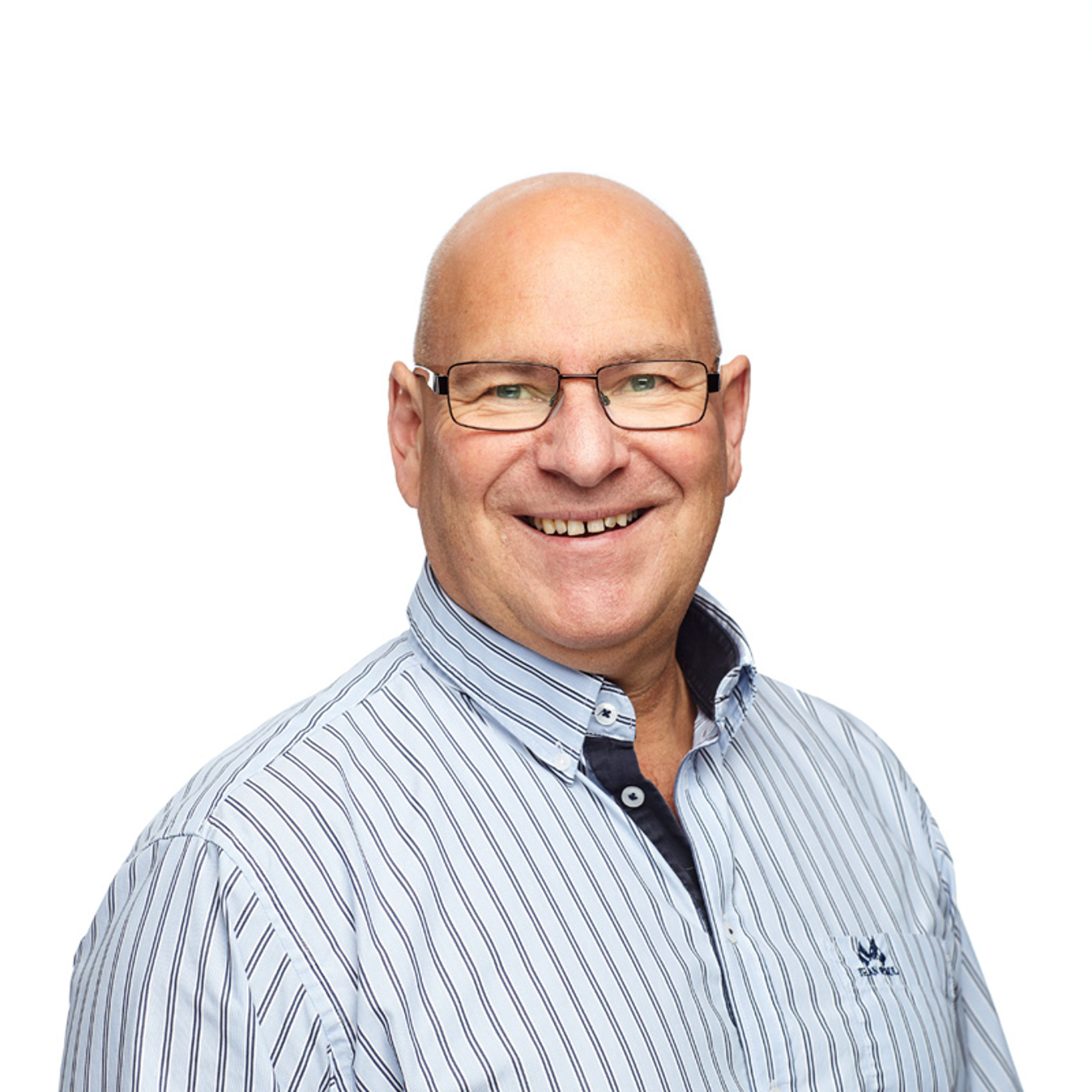 Mann med briller og stripete skjorte smiler mot kamera, hvit bakgrunn.